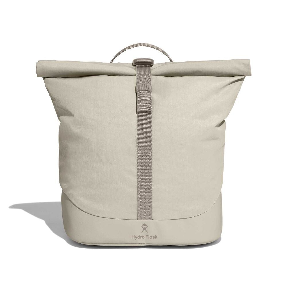 Minimalist light beige Hydro Flask roll-top backpack with central webbing strap and buckle, reinforced darker bottom, small top handle, and logo near base.