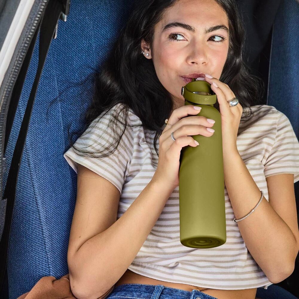 Olive-green Hydro Flask wide-mouth water bottle with powder-coated finish, screw-on lid, carry handle on metal pins, silver neck band, and logo on front.